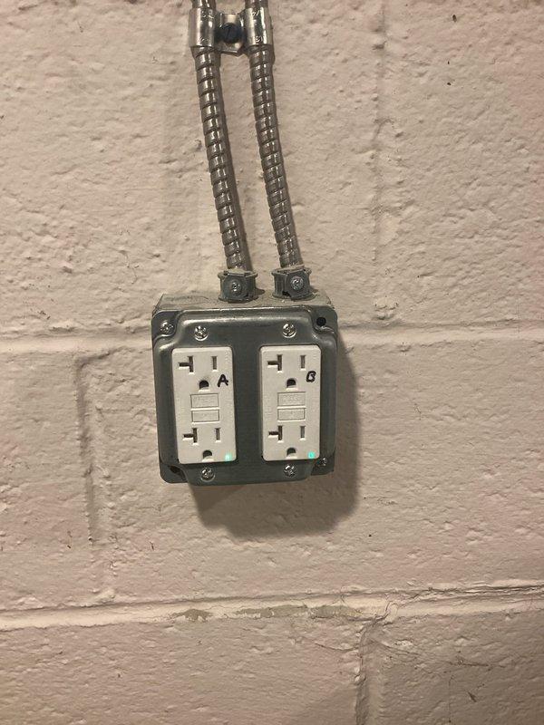 Installed a dedicated electrical circuit for sump pump operation in basement utility area. Ran flexible metal conduit along concrete block wall from panel to new dual GFCI receptacle outlet box, providing code-compliant ground fault protection for the sump pump system.