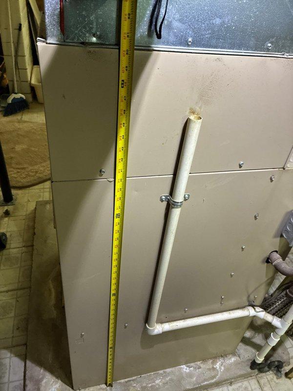 Conducted on-site assessment for HVAC system replacement in residential basement installation. Performed detailed measurements of existing furnace unit and supply ductwork to determine equipment specifications and clearance requirements for new system installation. Documented current equipment configuration including condensate drainage system with PVC piping arrangement and evaluated accessibility for replacement procedures.
