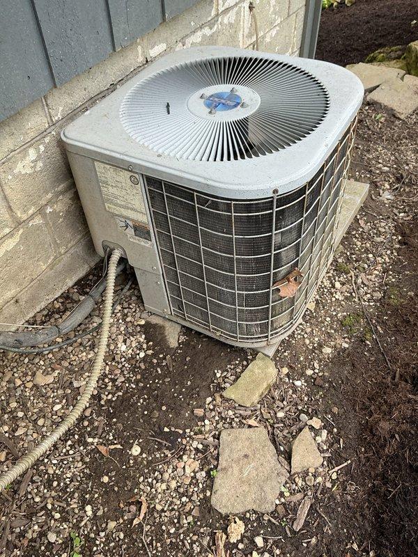 Responded to no cooling complaint on residential air conditioning system. Upon arrival, performed visual inspection of outdoor condenser unit, which showed signs of age and weathering with accumulated dirt and debris on exterior surfaces. Unit appeared operational but customer reported inadequate cooling performance. Documented equipment condition through photographs for service records.