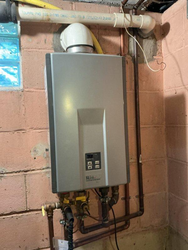 Performed routine maintenance flush on Rinnai tankless water heater unit to remove mineral buildup and sediment from the heat exchanger. Connected flushing equipment using black rubber hoses to isolate and circulate descaling solution through the system for optimal performance. Verified proper operation of all copper supply lines, shut-off valves, PVC exhaust venting, and control panel functions upon completion to ensure unit is operating at manufacturer specifications.