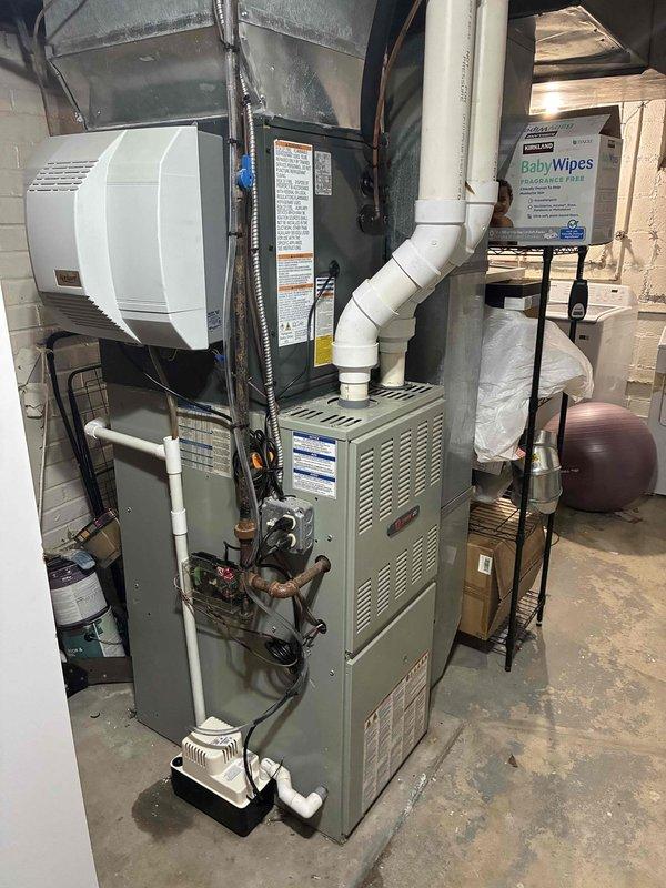 Completed installation of new outdoor A/C condensing unit with refrigerant line set connections to existing indoor furnace system. System commissioned, charged with refrigerant per manufacturer specifications, and verified operational with all safety labels properly affixed.