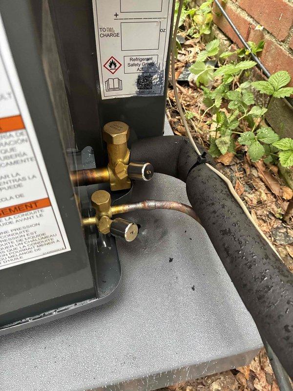 Completed installation of new outdoor A/C condensing unit with refrigerant line set connections to existing indoor furnace system. System commissioned, charged with refrigerant per manufacturer specifications, and verified operational with all safety labels properly affixed.
