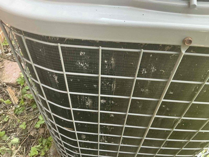 Performed comprehensive assessment of residential air conditioning system with visible hail damage to exterior condenser unit. Documented existing unit condition showing severely deteriorated condenser coils with substantial organic buildup and discoloration, indicating extended period without maintenance. Prepared detailed replacement estimate options and captured photographic documentation of damage for insurance claim submission, including measurements and system specifications for complete HVAC replacement proposal.