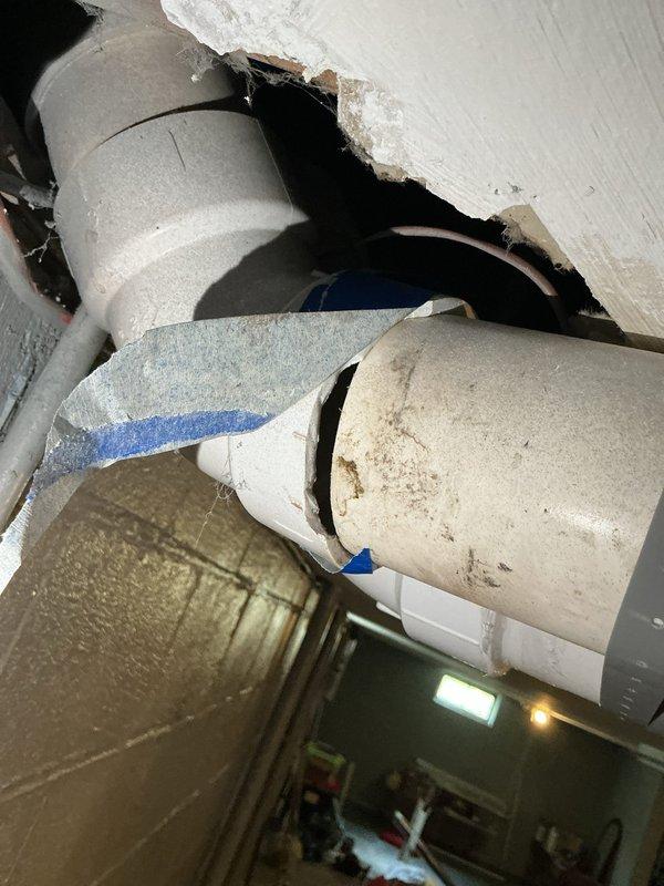 Responded to customer report of hole in pipe connected to furnace system. Upon inspection, discovered damaged drywall/ceiling material with exposed PVC venting pipes from furnace exhaust system. Documented existing conditions showing white PVC vent pipes with compromised ceiling access point and structural opening requiring attention. Assessed plumbing and venting infrastructure in crawl space area, noting PVC drainage/ventilation components with support strapping in place. Customer made aware of findings and photographic documentation completed for repair planning purposes.