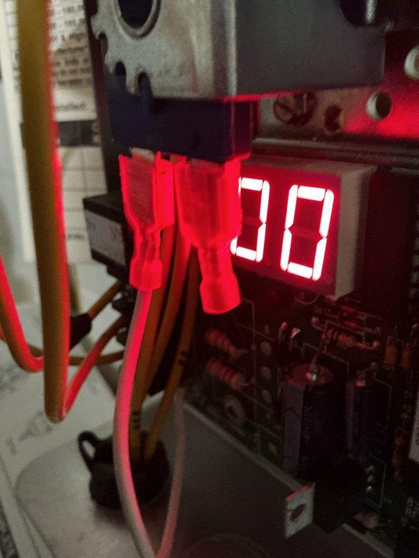Completed scheduled HVAC boiler maintenance inspection and system diagnostics. Verified proper operation of all electrical components, tested control board functionality with digital display reading 30°F, and performed amperage measurements using clamp meter to confirm system is operating within manufacturer specifications.