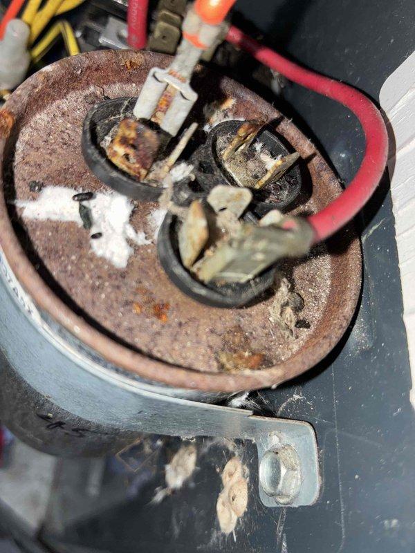 # HVAC Maintenance - Cooling System Service

Completed comprehensive cooling system maintenance on residential HVAC unit. During routine inspection, discovered a critically deteriorated capacitor with severe corrosion on the cylindrical housing and electrical terminals. The component exhibited extensive rust damage, burned terminal connections, and degraded insulation, indicating prolonged exposure to moisture and environmental stress. Replaced the failed capacitor with new OEM part to restore proper system operation and prevent compressor failure. Cleaned electrical connections, verified proper wire routing, and tested all electrical terminals for secure contact. System startup successful with normal amperage draw and proper cooling cycle operation confirmed.