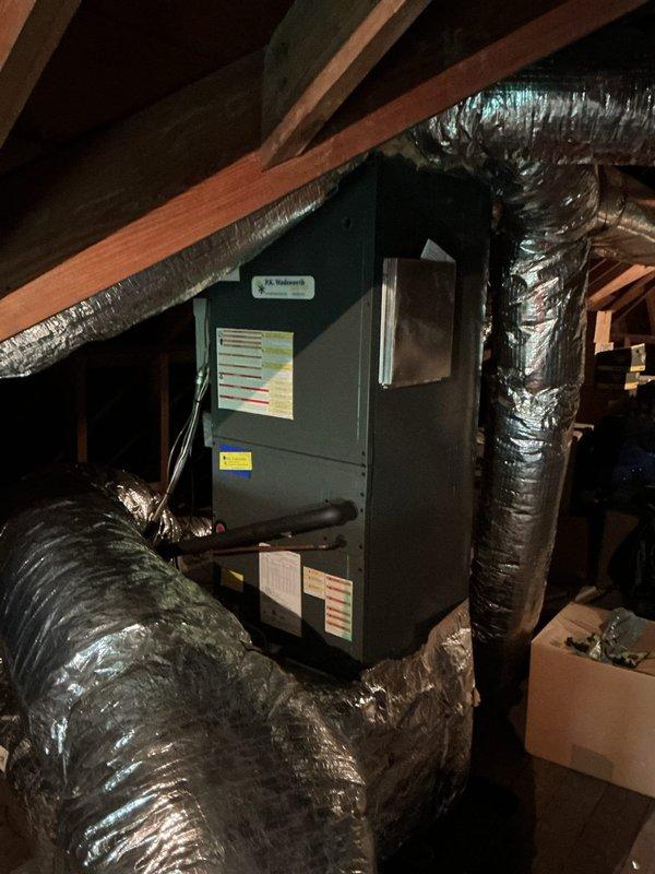 Performed comprehensive cooling maintenance on attic-mounted air handler system. Inspected evaporator coil assembly, noting dust accumulation on finned surfaces but confirmed structural integrity remains intact. Verified air handler unit installation, ductwork connections, and flexible duct insulation throughout attic space. All system components operational and properly secured within confined attic environment.