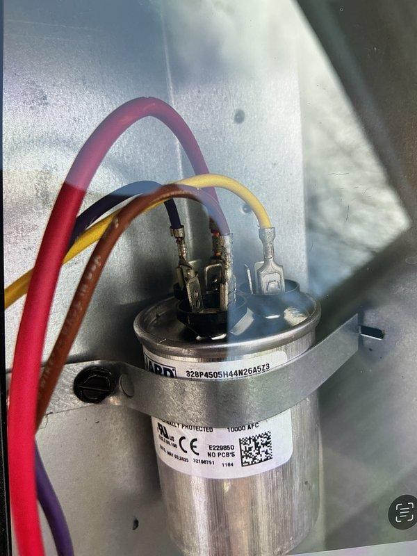 Completed comprehensive cooling system maintenance inspection. Examined and tested run capacitor, verified proper electrical connections and terminal integrity with multi-colored wire leads securely fastened. Inspected condensate drain line system in crawlspace, confirmed PVC drainage piping configuration and shut-off valves functioning properly. All components operating within normal parameters, system ready for cooling season.