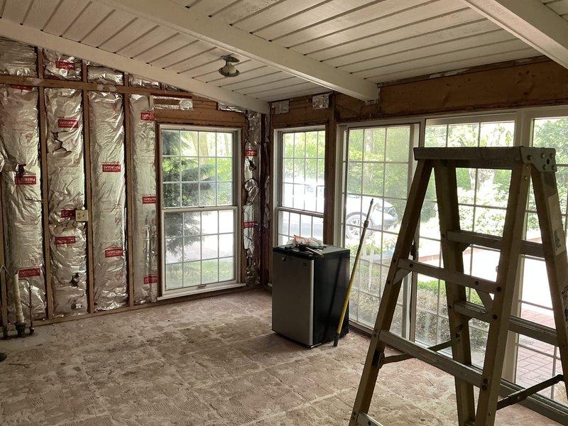 Conducted site assessment for mini split installation in addition space with potential second zone coverage. Evaluated room under construction with exposed stud walls, reflective insulation, and multiple windows to determine optimal unit placement and BTU requirements. Documented existing heating infrastructure including vintage baseboard units in upper level space and assessed compatibility with proposed ductless system as alternative to boiler replacement options.
