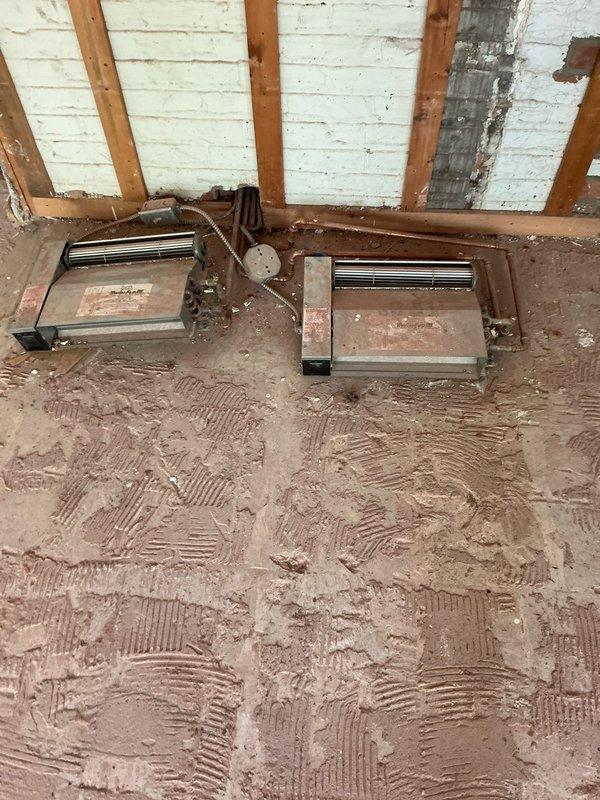 Conducted site assessment for mini split installation in addition space with potential second zone coverage. Evaluated room under construction with exposed stud walls, reflective insulation, and multiple windows to determine optimal unit placement and BTU requirements. Documented existing heating infrastructure including vintage baseboard units in upper level space and assessed compatibility with proposed ductless system as alternative to boiler replacement options.