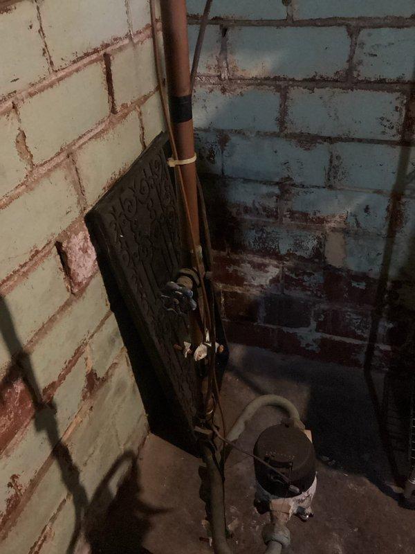 Conducted comprehensive plumbing inspection of residential basement and crawl space areas, documenting existing plumbing infrastructure including copper supply lines with shut-off valves, PVC drainage systems, and insulated piping. Assessed condition of mechanical components, noting wall-mounted copper piping with mounting brackets, multiple valve assemblies, and evidence of moisture-related deterioration on concrete block walls requiring future monitoring.