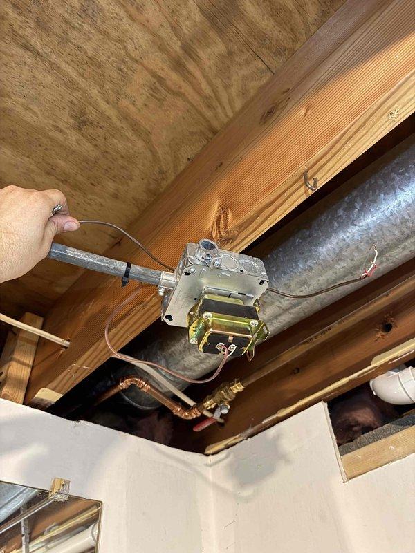 Responded to no-heat call following recent tankless water heater installation with electrical work. Performed diagnostic testing on HVAC transformer and electrical connections in attic space using voltage tester. Verified proper wiring connections, tested transformer output, and inspected junction box connections to restore system operation.