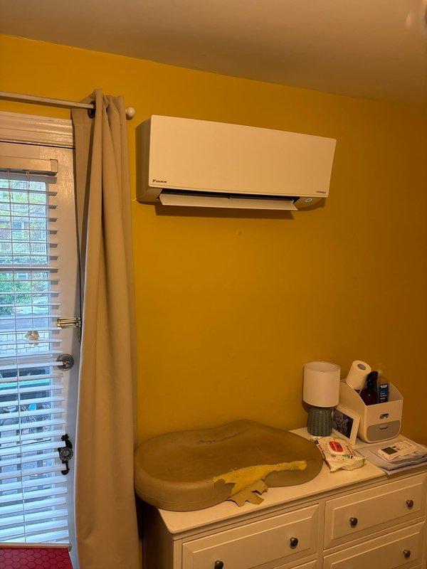 Completed installation of Daikin ductless mini-split air conditioning system in residential bedroom/nursery space. Wall-mounted indoor unit installed high on interior wall per manufacturer specifications, system tested and verified operational.