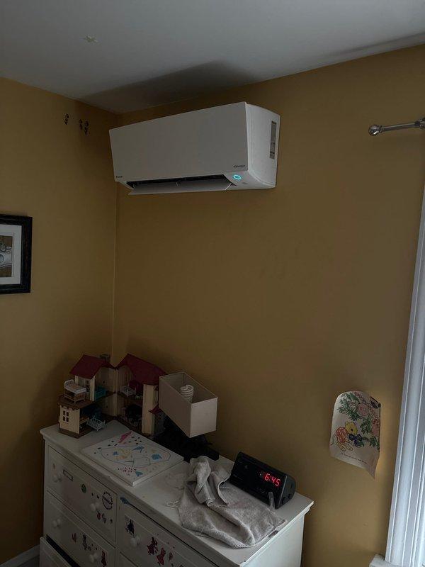 Completed installation of Daikin ductless mini-split air conditioning system in residential bedroom/nursery space. Wall-mounted indoor unit installed high on interior wall per manufacturer specifications, system tested and verified operational.