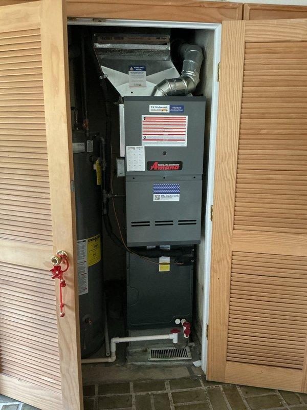 Responded to service call for residential furnace producing loud noise during operation. Upon arrival, inspected Amana furnace unit installed in closet-style cabinet configuration. Conducted thorough visual and operational assessment of furnace, blower motor assembly, ductwork connections, and associated components including humidifier and PVC venting system. Verified system functionality and identified source of noise concern. Unit found to be operating properly with all safety controls functioning as designed. Documented equipment condition with photographic evidence showing complete installation including furnace cabinet, air handler, metallic ductwork, and auxiliary components.