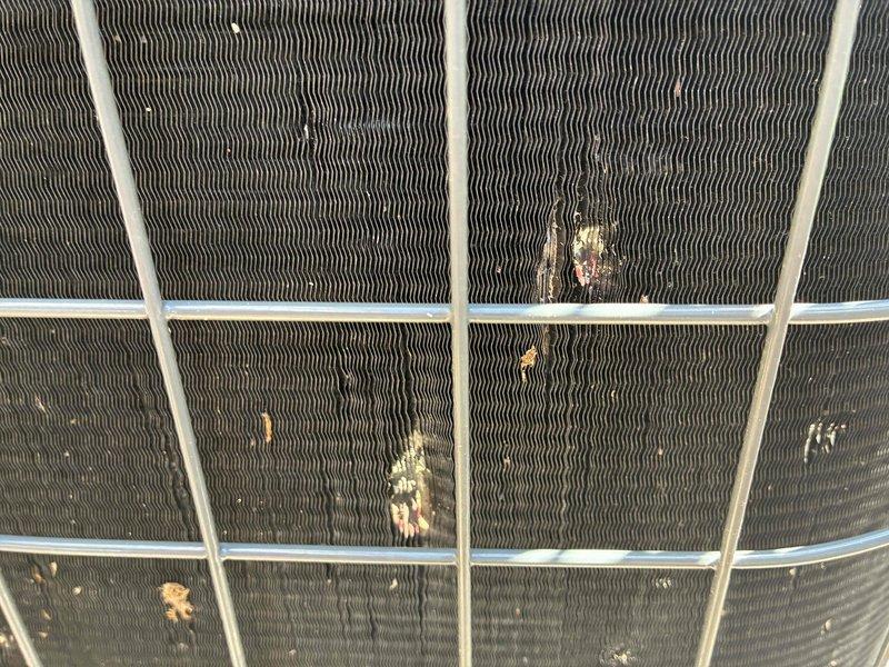 Completed comprehensive cooling system maintenance on outdoor condenser unit. Performed visual inspection revealing moderate fin damage with bent and compressed sections, along with corrosion and rust deposits on condenser coil surfaces. Assessed hail damage to fins and protective grille, documented equipment condition with photographs for repair quotation purposes.
