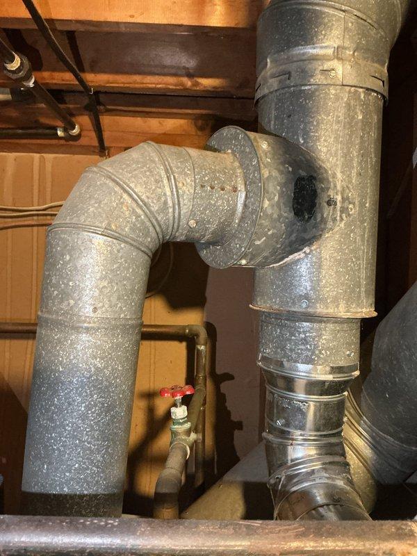 Responded to service call regarding improper venting configuration between water heater and HVAC system sharing common vent stack, as identified during property appraisal inspection. Assessed existing galvanized ductwork and venting arrangement in mechanical space where furnace and air conditioning system were previously installed. Performed necessary repairs to furnace duct tube connections and corrected venting issues to ensure proper exhaust separation and code compliance for both water heater and HVAC equipment.