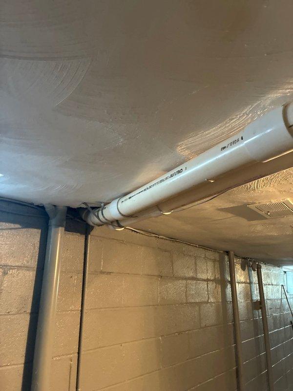 Responded to warranty callback for flue pipe repair that was not properly completed during previous service visit. Accessed and inspected PVC flue pipe installation in basement utility area, identifying improper connections and deteriorated coupling joint with visible staining and discoloration. Repaired flue pipe penetration through wall assembly, ensuring proper sealing and code-compliant installation of venting system. Documented existing conditions and completed repairs to restore proper ventilation function for HVAC equipment.