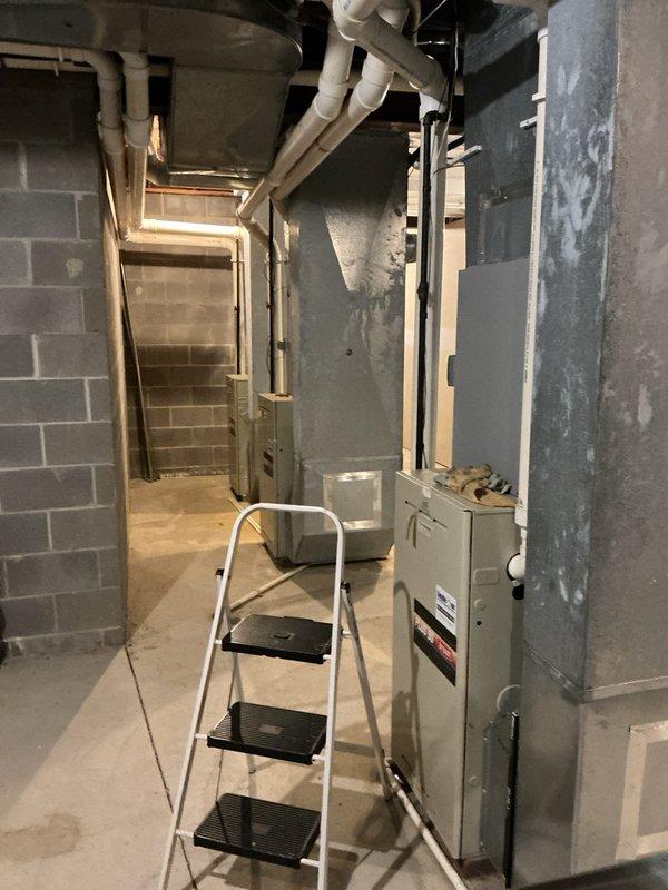 Responded to customer complaint of uneven heating and cooling throughout residence. Performed comprehensive system evaluation on Bryant Plus 90 high-efficiency furnace located in basement utility area. Conducted visual inspection of unit exterior, verified manufacturer labels and service history documentation present on equipment. Assessed overall system condition, noting unit age undetermined but estimated based on model specifications. Inspected ductwork connections, PVC venting system, and mechanical components for proper installation and potential airflow restrictions. Documented equipment model information and current operating configuration with photographic evidence for service records.