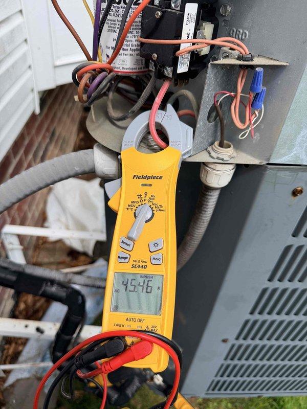 Performed comprehensive cooling system maintenance on outdoor condensing unit. Conducted electrical diagnostics using digital multimeter, verifying control voltage at contactor measured 45.76V and confirming proper wire connections throughout electrical panel. Measured compressor amperage draw at 18.8A using clamp meter, indicating normal operating parameters within manufacturer specifications. All electrical components, wiring connections, and contactors inspected and found in proper working condition with no deficiencies noted.