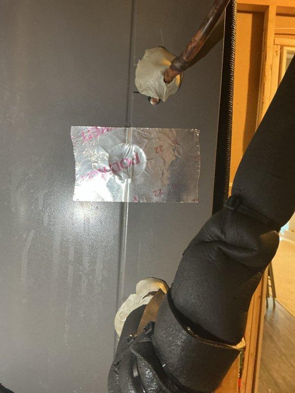 Completed routine HVAC cooling system maintenance including inspection of refrigerant line insulation at wall penetrations and verification of equipment labeling and wiring connections. System components were found in operational condition with minor insulation wear noted on copper refrigerant lines.