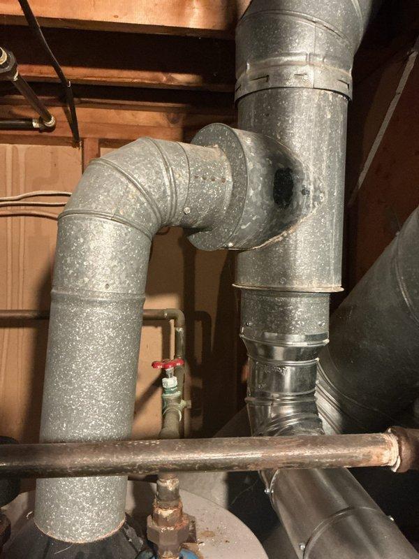 Replaced damaged flue pipe section on HVAC system. Installed new galvanized ductwork with proper T-junction configuration and secure connections to ensure safe venting of combustion gases. System tested and verified proper operation upon completion.