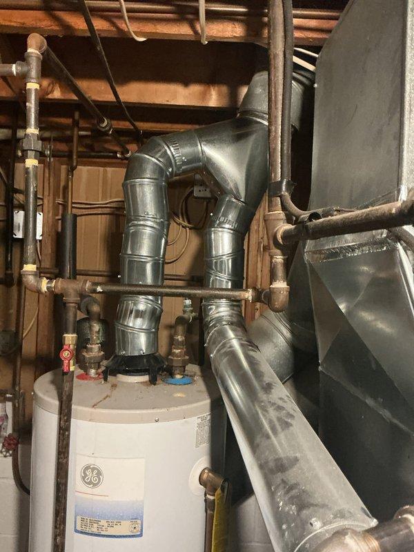Replaced damaged flue pipe section on HVAC system. Installed new galvanized ductwork with proper T-junction configuration and secure connections to ensure safe venting of combustion gases. System tested and verified proper operation upon completion.