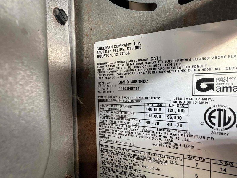 Responded to no heat call on Goodman forced air furnace (Model: GMHB1405DNCC). Upon inspection, unit would not initiate heating cycle. Diagnosed system failure, documented equipment specifications and internal components including blower assembly, refrigerant lines, and electrical connections for service records.