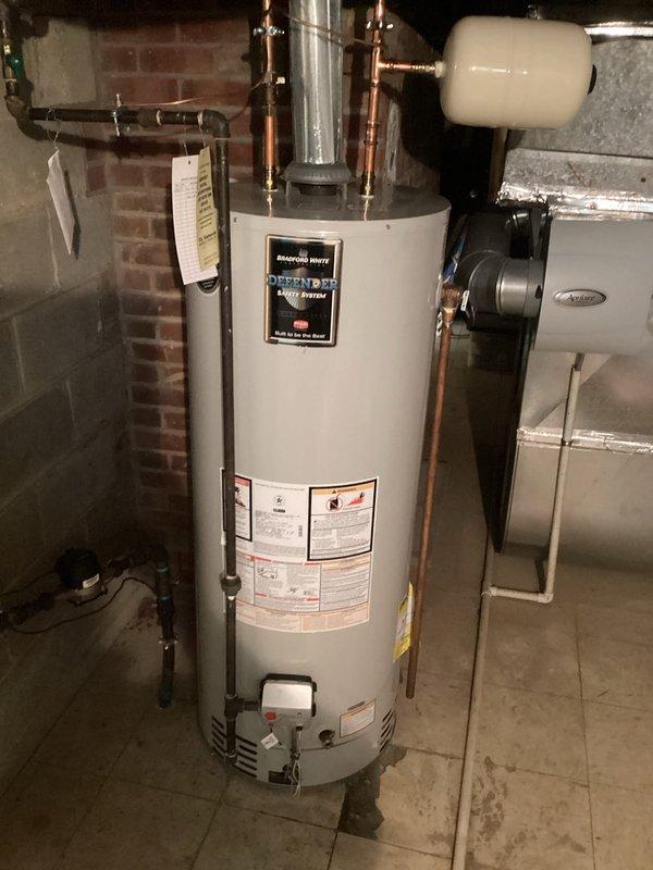 Responded to no hot water complaint at residential property. Upon arrival, inspected Bradford White Defender Safety System tanked water heater in basement utility area. Examined gas control valve and pilot assembly on unit. Found Honeywell gas control valve in OFF position. Relit pilot light following manufacturer's lighting procedures, verified proper flame characteristics, and restored gas control to operational temperature setting. Confirmed hot water restoration and proper unit function before departure.