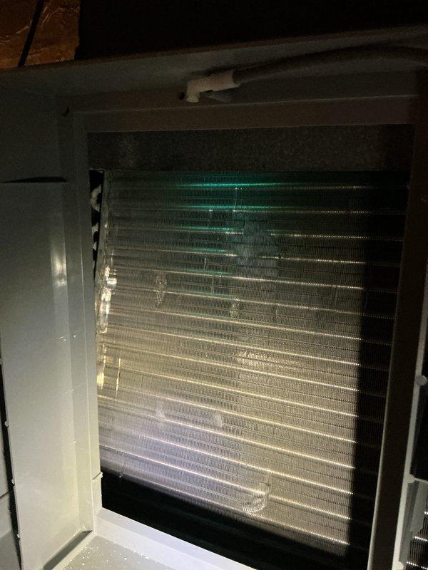Completed scheduled cooling system maintenance on attic-mounted air handler unit. Accessed evaporator coil assembly through front service panel and performed thorough inspection of coil fins and heat exchanger surfaces. Coil fins showed relatively clean condition with minimal debris accumulation. Noted evidence of previous moisture exposure and minor oxidation on metal framework and base components, though coil integrity remains intact. Unit operational and functioning within normal parameters following maintenance completion.