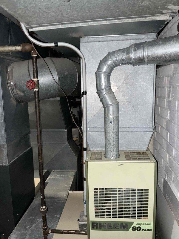 Conducted comprehensive evaluation of existing downstairs HVAC system for full replacement estimate. Assessed current Rheem Imperial 80 Plus heating unit, existing ductwork configuration, and mechanical room layout in basement utility area. Documented equipment specifications, clearances, and connection points including supply ductwork, electrical service, and gas piping to provide accurate replacement options for complete system upgrade.