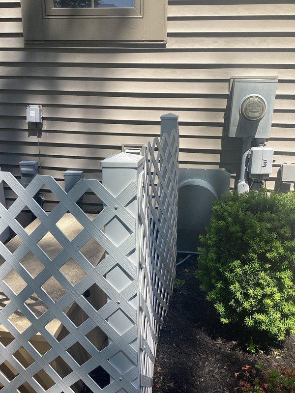 Responded to service call for non-operational Generac generator that was failing to start or transfer power during outage conditions. Performed comprehensive diagnostic testing of the generator's starting battery using electronic battery analyzer, which indicated battery failure and displayed "REPLACE" status. Diagnosed failed battery as root cause preventing generator from initiating startup sequence. Generator system and associated transfer switch equipment located at exterior of residence behind decorative lattice screening.