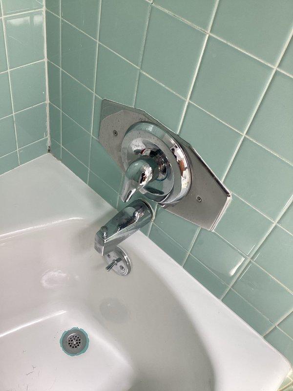 Completed installation of two valves in the slop sink and replaced shower head and handle assembly in the bathtub using customer-supplied hardware. All fixtures tested and verified for proper operation with no leaks detected.