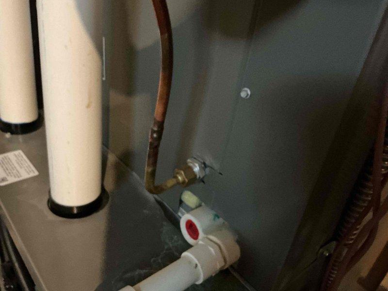 Responded to no cooling complaint on residential air conditioning system. Upon arrival, performed diagnostic inspection of HVAC equipment including furnace/air handler unit and associated components. Inspected condensate drain system with PVC piping, verified proper installation of safety switches and pressure relief mechanisms. Documented equipment condition through photographic records showing furnace cabinet, ductwork connections, copper refrigerant lines, and auxiliary components in mechanical space.