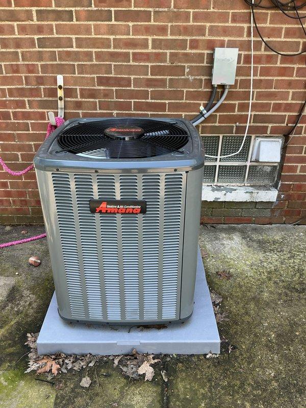 Responded to no-cooling call on 2-month-old Amana air conditioning system. Upon arrival, confirmed thermostat was set to cool mode with fan on auto, indoor temperature at 80°F with setpoint at 70°F, but system was not initiating. Inspected outdoor condensing unit and found equipment in good physical condition with proper electrical connections at disconnect box. Diagnosed and resolved thermostat communication issue preventing system call for cooling. Verified proper system startup, confirmed compressor and condenser fan operation, and tested full cooling cycle. System now operating normally and maintaining setpoint temperature.