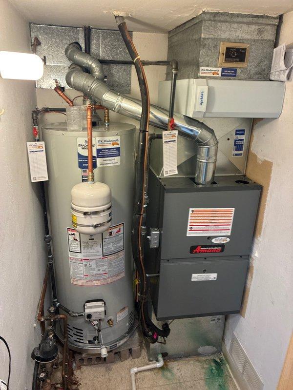 Completed installation of 80% efficiency Amana furnace with liner and water heater replacement in residential mechanical room. Relocated refrigerant lineset by pumping AC system into itself to safely maneuver existing equipment and facilitate new water heater installation in confined space. Verified system operation with manometer readings showing balanced static pressures of 361-362, confirming proper airflow and equipment function. All equipment operational and installation complete per manufacturer specifications.