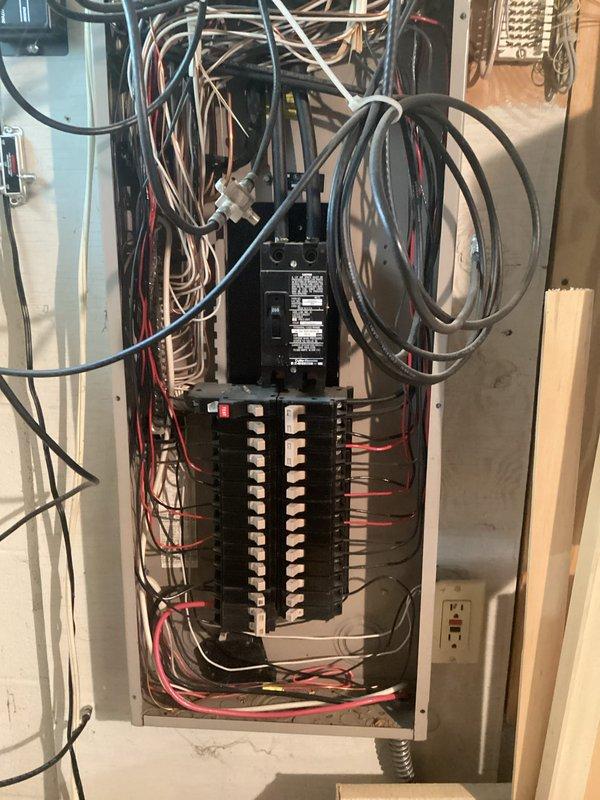 Completed comprehensive whole home electrical inspection during afternoon service call. Performed thorough evaluation of main electrical panel, verifying proper circuit breaker installation, wire routing, and connection integrity throughout the distribution system. Documented panel configuration showing dual-row breaker arrangement with mixed conductor types entering from overhead service entrance. Inspected all visible wiring for code compliance, proper color coding, and secure terminations at bus bars. Evaluated flexible conduit entry points and grounding system integrity. Assessed workspace electrical outlets and connected equipment for proper functionality and safety. Captured photographic documentation of panel interior components and general electrical infrastructure for service records.