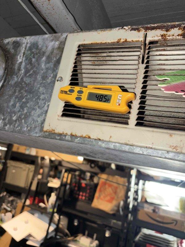 Completed comprehensive cooling system tune-up on residential HVAC unit. Performed standard maintenance procedures including temperature diagnostics at supply register (recorded 48.5°F discharge temperature), inspected outdoor condenser unit condition and airflow, verified refrigerant line connections, and assessed overall system operation. Unit operating within normal parameters; noted age-related cosmetic wear on interior grille component with rust staining present but not affecting system performance.