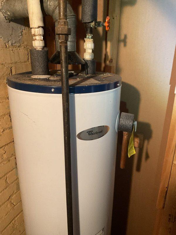 Responded to service call for Whirlpool tanked water heater experiencing excessive noise and reduced hot water capacity. Performed comprehensive inspection of unit, plumbing connections, valves, and venting system. Documented current condition of water heater installation, including all pipe connections, pressure relief valve, and insulation. Photographed unit specifications and manufacturer labels for service records.