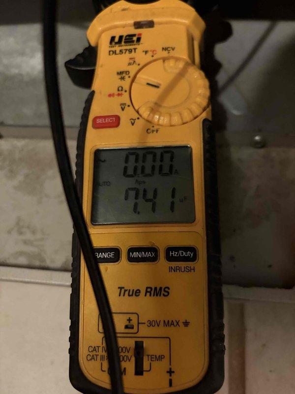 Completed routine HVAC cooling system maintenance inspection and diagnostics. Performed electrical measurements using digital multimeter to verify proper voltage and amperage readings, and recorded temperature readings at key system components showing 134.4°F, confirming normal operating parameters for the cooling equipment.