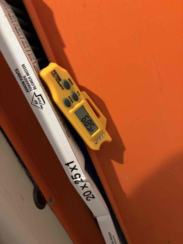 Completed routine HVAC cooling system maintenance inspection and diagnostics. Performed electrical measurements using digital multimeter to verify proper voltage and amperage readings, and recorded temperature readings at key system components showing 134.4°F, confirming normal operating parameters for the cooling equipment.
