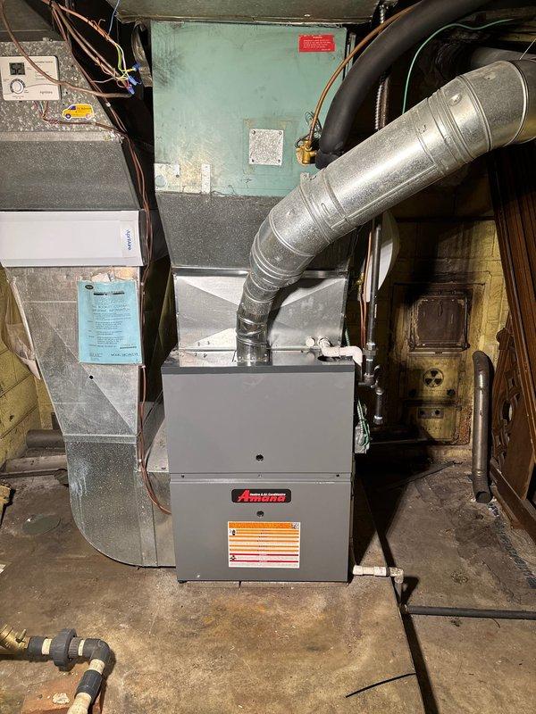 Completed installation of new Amana 96% AFUE high-efficiency gas furnace in basement mechanical room. Unit installed on concrete floor with proper clearances, connected to existing ductwork via metallic supply plenum and flexible return duct, all connections sealed to manufacturer specifications. Full payment collected upon completion of installation.