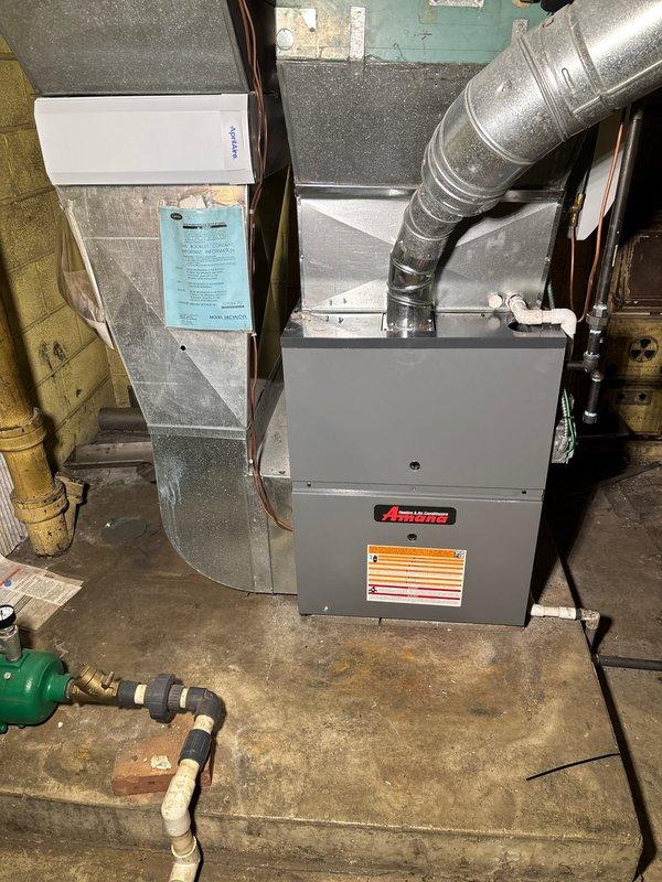Completed installation of new Amana 96% AFUE high-efficiency gas furnace in basement mechanical room. Unit installed on concrete floor with proper clearances, connected to existing ductwork via metallic supply plenum and flexible return duct, all connections sealed to manufacturer specifications. Full payment collected upon completion of installation.