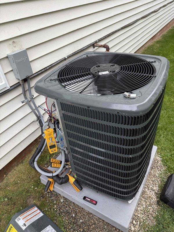 Completed full HVAC system installation including 96% efficiency furnace and air conditioning unit. Installed outdoor condensing unit on gravel pad with proper refrigerant line connections, mounted electrical disconnect box, charged system to manufacturer specifications as verified with manifold gauges, and programmed new Honeywell Home thermostat with temporary and permanent hold functions. System tested and operating within normal parameters.