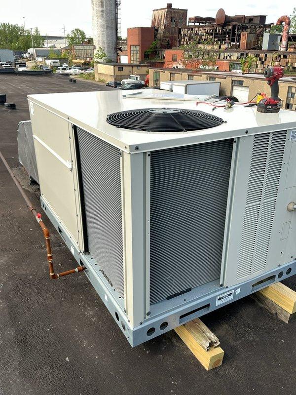 Responded to no cooling complaint on rooftop package unit. Upon arrival, found unit installed on elevated wooden platform with copper refrigerant lines visible. Performed diagnostic evaluation of system to determine cause of cooling failure and documented equipment condition with photographs for service records.