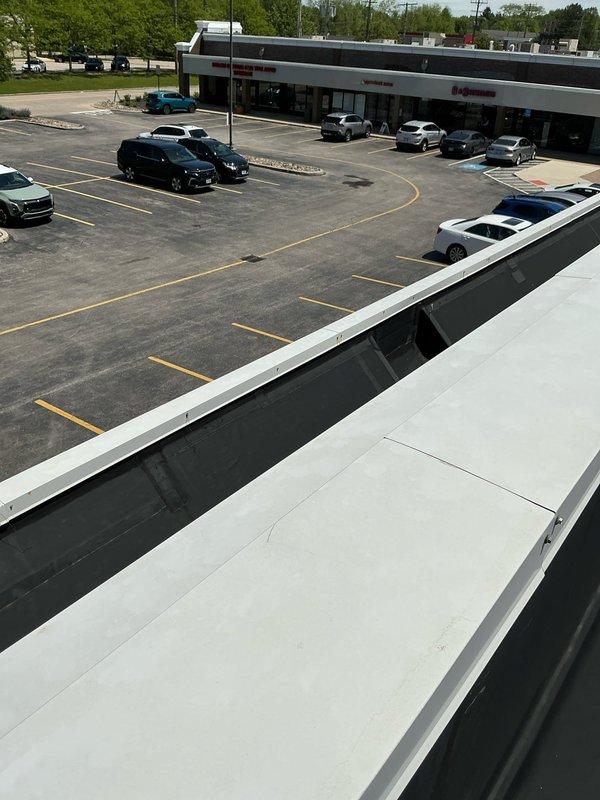 Conducted commercial rooftop unit assessment for hail damage on 11-12 ton RTU system. Documented extensive equipment damage from storm event for ongoing insurance claim, photographed thermostat and rooftop conditions, and provided repair estimate for damaged cooling equipment.