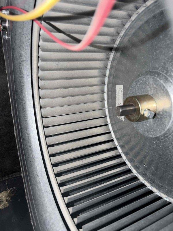Performed comprehensive cooling system maintenance on HVAC unit. Completed inspection of blower assembly and squirrel cage fan wheel, noting normal dust accumulation on blades and housing. Examined ventilation grille and louver panel, observing expected dirt and debris buildup within recessed openings. Delivered replacement air filter and batteries for outdoor temperature sensor as requested. System operational and ready for cooling season.