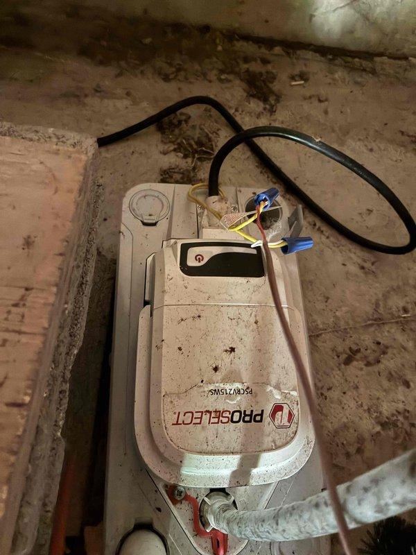 Responded to no cooling call on residential air conditioning system. Upon arrival, customer reported unit not coming on with no cool air being produced. Performed diagnostic inspection of HVAC equipment located in crawlspace area. Examined ProSelect condensate pump assembly and electrical connections, noting accumulated dirt and grime on unit housing. Inspected control panel wiring and internal components, checking all electrical connections including wire nuts and low voltage wiring bundle. Verified proper connections on white plastic terminal block and examined condition of foil-lined control housing. Addressed service issue and restored system to proper operating condition.