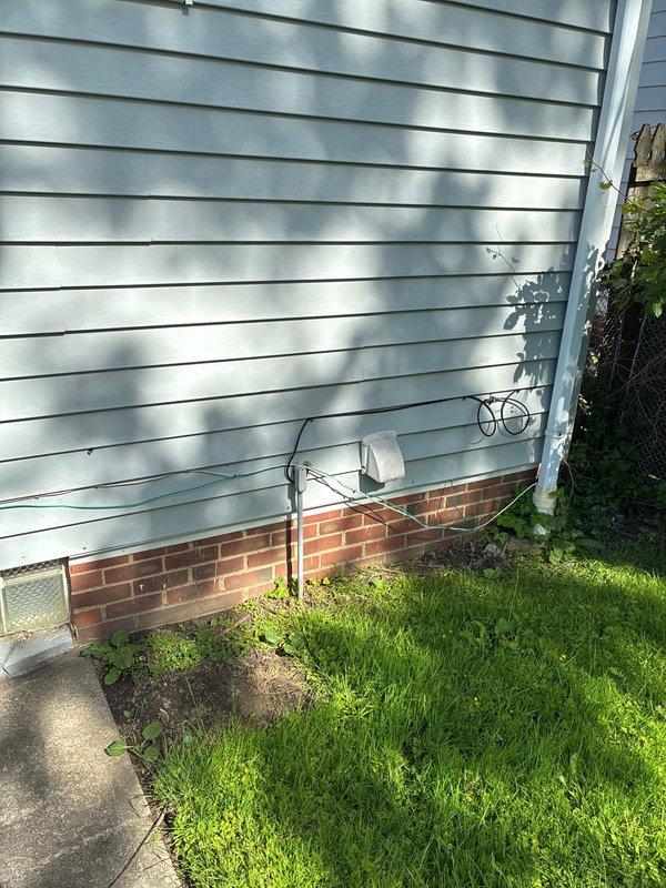 Conducted on-site evaluation of existing HVAC system for residential air conditioning replacement options. Assessed current furnace and ductwork configuration in basement utility area, documenting equipment specifications and existing infrastructure including metallic supply ductwork and venting arrangements. Evaluated exterior wall penetrations and utility line routing to determine optimal placement for new condensing unit installation on brick foundation area with adequate clearance from landscaping and building structure.