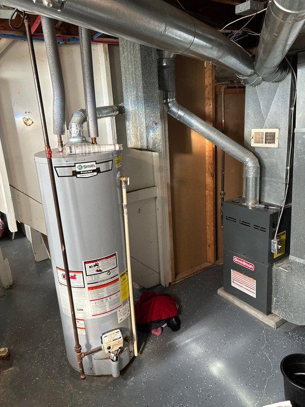 Conducted on-site evaluation of existing HVAC system for residential air conditioning replacement options. Assessed current furnace and ductwork configuration in basement utility area, documenting equipment specifications and existing infrastructure including metallic supply ductwork and venting arrangements. Evaluated exterior wall penetrations and utility line routing to determine optimal placement for new condensing unit installation on brick foundation area with adequate clearance from landscaping and building structure.